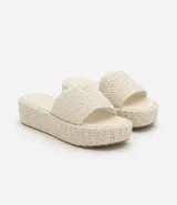 Sandalia tipo flatform con suela de plataforma plana y tira ancha superior, ambas con textura trenzada. Diseño sin cierre con puntera redonda.