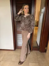 Camisa de color marrón chocolate con estampado floral en tono beige, de corte relajado, manga larga con puños elásticos y cierre frontal con botones.