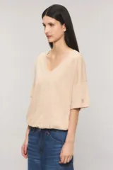 Remera oversize color blanco, confeccionada en jersey Pima flamé de algodón. Cuenta con escote en V, mangas cortas con detalle de bordado en la manga y cintura con elástico que genera un efecto balloon.