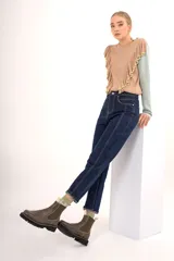 Pantalón jean azul oscuro de tiro alto con pierna recta, pretina con botones metálicos y cierre frontal con botón y cremallera.