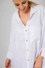 Túnica blanca estilo camisa, larga hasta la rodilla, con cuello clásico, abotonada al frente y aberturas laterales.