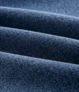 Pantalón de jean recto Ashua, color azul medio con efecto desgastado sutil. Presenta cintura con presillas, cierre frontal con botón y bolsillos funcionales.