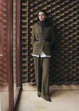 Blazer verde militar, de corte estructurado, con solapas de muesca, bolsillos con solapa y cierre frontal de un botón.