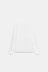 Camisa de cuello solapa y escote en pico, con manga larga y cierre frontal mediante botones. Presenta un diseño fluido con bajo asimétrico y aberturas laterales.