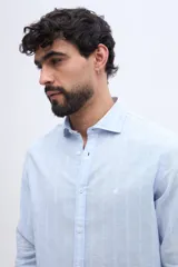 Camisa de manga larga con diseño de rayas verticales, confeccionada en mezcla de lino y algodón, con cuello camisero y cierre frontal de botones.