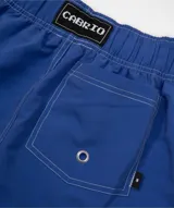Short de baño azul eléctrico con cordón de ajuste beige y costuras blancas visibles. Presenta un pequeño logo bordado en forma de asterisco en la parte inferior derecha.