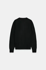 Jersey de punto liso color verde, con cuello redondo y manga larga. Confeccionado en lana suave.