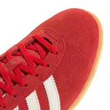 Zapatillas Adidas Gazelle Lo Pro de gamuza color rojo con las tres tiras laterales en blanco y suela de goma color caramelo.