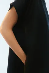 Vestido midi evasé color azul, confeccionado en lino, con escote redondo, mangas cortas con dobladillo vuelto y bolsillos laterales. Presenta un ruedo asimétrico, más largo en los laterales.
