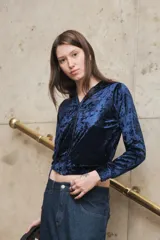 Campera azul de terciopelo con cierre frontal, mangas largas y bolsillos laterales.