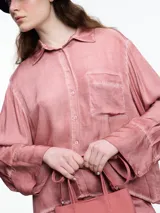 Camisa de manga larga confeccionada en viscosa teñida en frío, con efecto gastado. De corte relajado, con bolsillo delantero y puños amplios. El desgaste de color en las costuras le da un aire descontracturado.