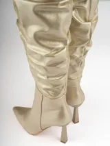 Bucanera dorada de caña alta con efecto arrugado y taco geométrico.