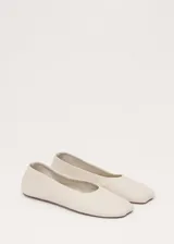 Zapato chatita de cuero ovino color beige, de diseño minimalista con punta redonda y suela de cuero.