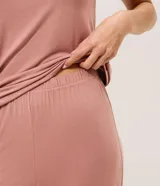 Pijama largo de dos piezas confeccionado en viscolycra color rosado. Incluye una remera de manga corta con escote en V adornado con encaje y un pantalón de corte recto con cintura elástica.
