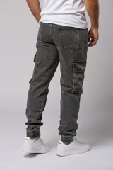 Pantalón jean gris oscuro de corte jogger con bolsillos cargo laterales y puños elásticos en los tobillos.