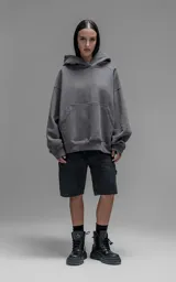 Hoodie oversize de corte crop, color gris oscuro, confeccionado en frisa de algodón. Presenta capucha forrada, bolsillo tipo canguro frontal y puños elásticos.