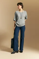 Remera de calce relajado con silueta fluida, confeccionada en tejido de viscosa con elastano. Presenta cuello redondo, mangas cortas y un diseño minimalista de caída suave.