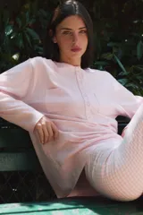 Camiseta rosada de manga larga con cuello panadero, cierre frontal con botones y bolsillos de parche en el pecho.