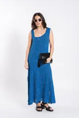 Vestido largo de tejido de punto azul con brillo, sin mangas, escote cuadrado y diseño acampanado.
