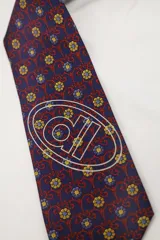 Corbata de poliéster color borgoña con estampado geométrico y logo de la marca serigrafiado en blanco.