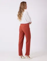 Pantalón sastrero de corte slim, color blanco, con pretina anatómica y panel interno modelador. Presenta bolsillos laterales tipo ojal, bolsillos traseros simulados y nervadura vertical marcada en el frente.