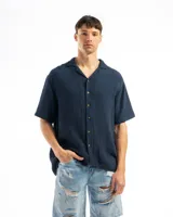 Camisa color crema de tela tetra de algodón, de corte suelto, manga corta y cuello cubano.