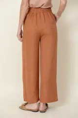 Pantalón ancho color ladrillo, de viscosa y poliéster, con cintura elastizada, cordón para ajustar y bolsillos laterales.