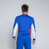 Buzo deportivo de manga larga, color azul, con cuello redondo y detalles en rojo y blanco en los laterales. Presenta el logo de Umbro y el escudo del Club Nacional de Football en el pecho.