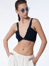 Top negro con escote regulable y breteles ajustables que se pueden atar en el delantero o espalda.