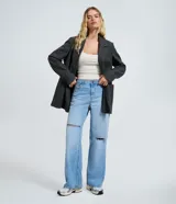 Pantalón wide leg de jean color celeste, con cintura baja, bolsillos funcionales, cierre de botón y cremallera, y roturas decorativas en las rodillas.