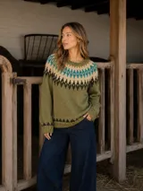 Buzo de lana merino con diseño tejido de inspiración nórdica. Presenta un patrón geométrico en tonos oliva, crudo y turquesa alrededor del cuello y en el ruedo. Tiene cuello redondo, mangas largas con puños acanalados y un calce relajado.