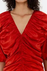 Vestido midi color rojo con escote en V, mangas cortas abullonadas y frunces en la parte delantera.