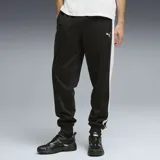 Pantalón deportivo Puma modelo ESS T7, color negro con franjas laterales blancas y logo de la marca bordado en el muslo. Presenta puños elásticos en los tobillos y bolsillos laterales.