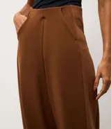 Pantalón de corte recto confeccionado en tejido de modal con mezcla de poliéster y elastano. Presenta un diseño minimalista con cintura elástica y costuras verticales que aportan estructura a la prenda.
