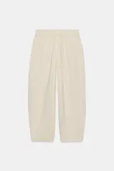 Pantalón de lino marrón oscuro, de corte barrel con pernera holgada que se estrecha hacia el tobillo, cintura elástica y bolsillos delanteros.