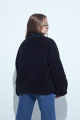 Campera de corderito color marrón oscuro, con cuello camisero y cartera frontal en tela lisa a tono. Presenta cierre mediante botones a presión y mangas largas con puños elásticos.