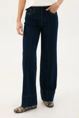 Pantalón de jean azul oscuro, de corte acampanado, con bolsillos delanteros y traseros, y costuras verticales en el frente.