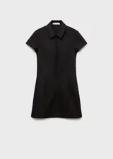 Vestido corto entallado de color negro, con cuello camisero y cierre frontal de cremallera invisible. Presenta mangas cortas y costuras decorativas verticales que estilizan la figura.