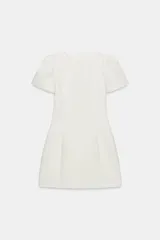 Vestido corto de cuello barco y manga corta abullonada. Presenta diseño con pliegues, falsos bolsillos de vivo en el delantero y costuras marcadas. Cierre en espalda con cremallera oculta.