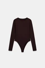 Body de manga larga y cuello redondo, confeccionado en tejido de poliamida. Presenta cierre inferior con botones a presión.