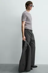 Camiseta de punto canalé slim fit, con cuello redondo y manga corta. Presenta un estampado de rayas horizontales en blanco, negro y rosado.