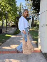 Cartera tipo hobo de cuero color beige con flecos en dos niveles.