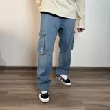 Pantalón jean cargo negro de corte recto y tiro medio, con bolsillos laterales con solapa.