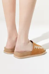 Sandalias bajas color marrón, con base de corcho y tira ancha de gamuza con pespuntes decorativos en hilo dorado.