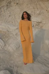 Vestido largo de tejido de punto negro con escote en la espalda y mangas largas.