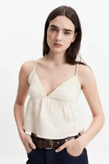 Musculosa de tiras finas color crema, con escote en V y vuelo en la base.