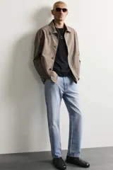 Pantalón de jean corte slim fit con efecto lavado, tiro medio, cinco bolsillos y cierre frontal con cremallera y botón.