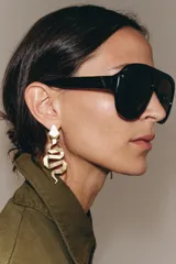 Pendientes colgantes con diseño geométrico de serpiente en acabado metálico dorado.