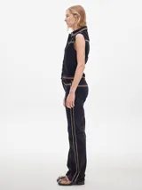 Pantalón de pana roja con corte holgado y tiro medio. Presenta una línea dorada a lo largo de la pierna.