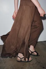 Vestido largo color marrón con detalle de crochet en el corpiño, escote redondo y manga corta. Cierre en la espalda con lazadas.